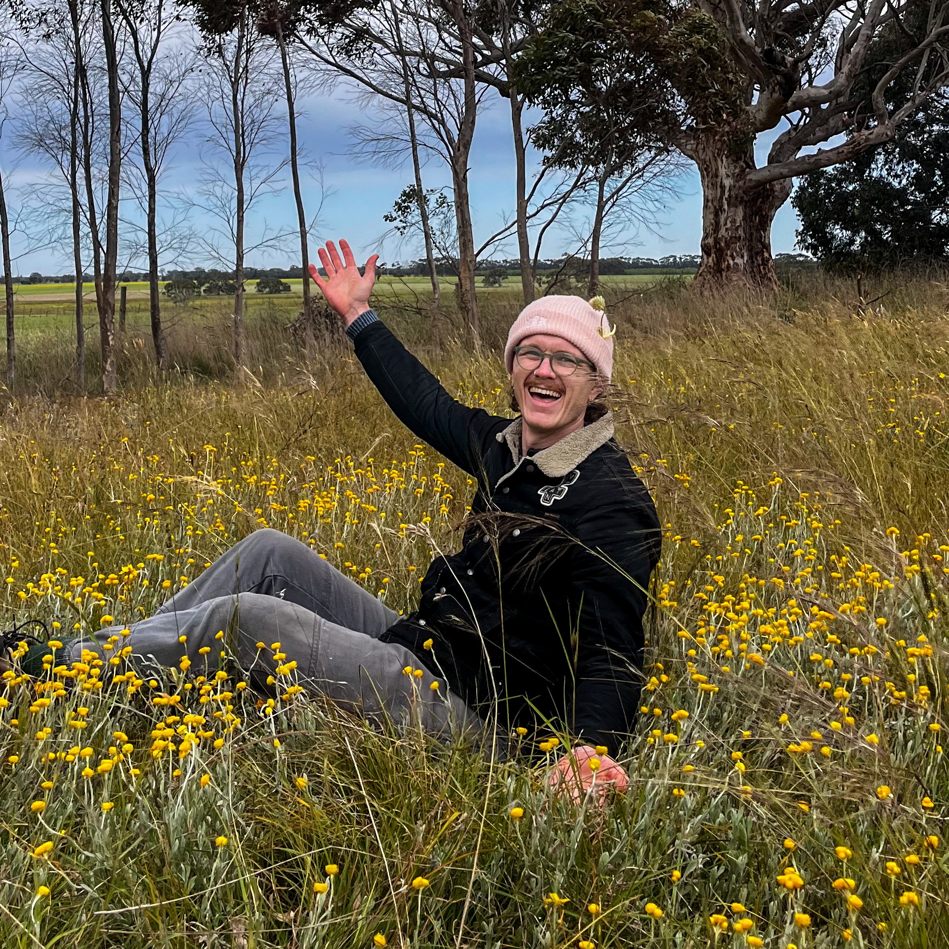 Jake, the campus coordinator in his natural habitat - sitting in a victorian grassland rich in flowers and grasses.